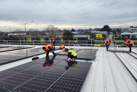 Why does the choice of material for flat roof PV racking affect the overall performance of the system?